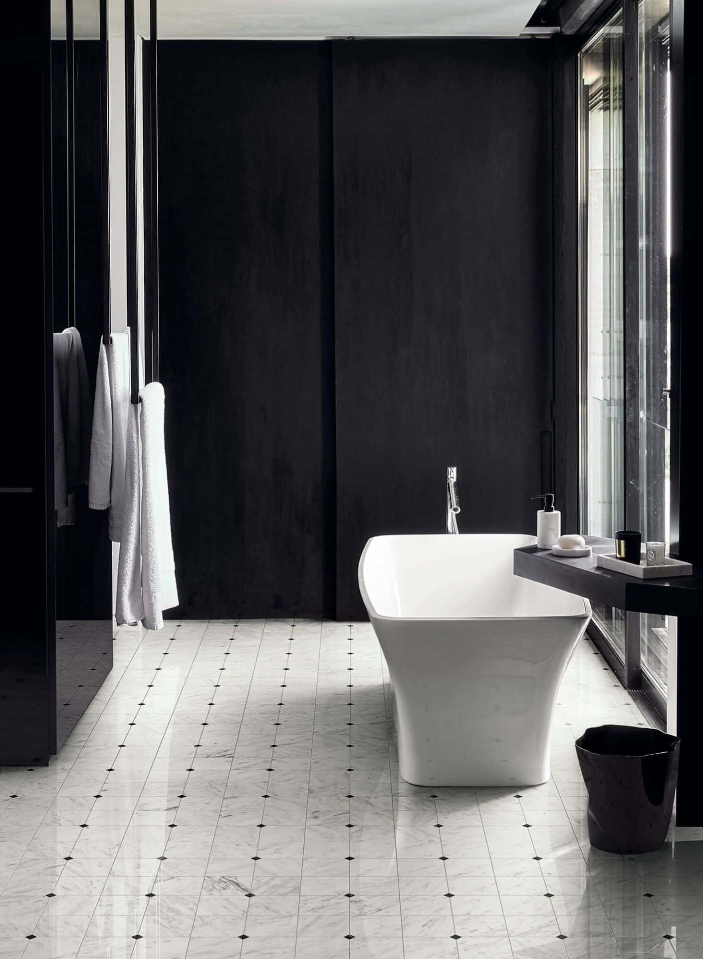 Ambiente de casa de banho com decoração a preto e branco. Chão em mármore branca com pormenores a preto. Bisazza, coleção Marmo Lux