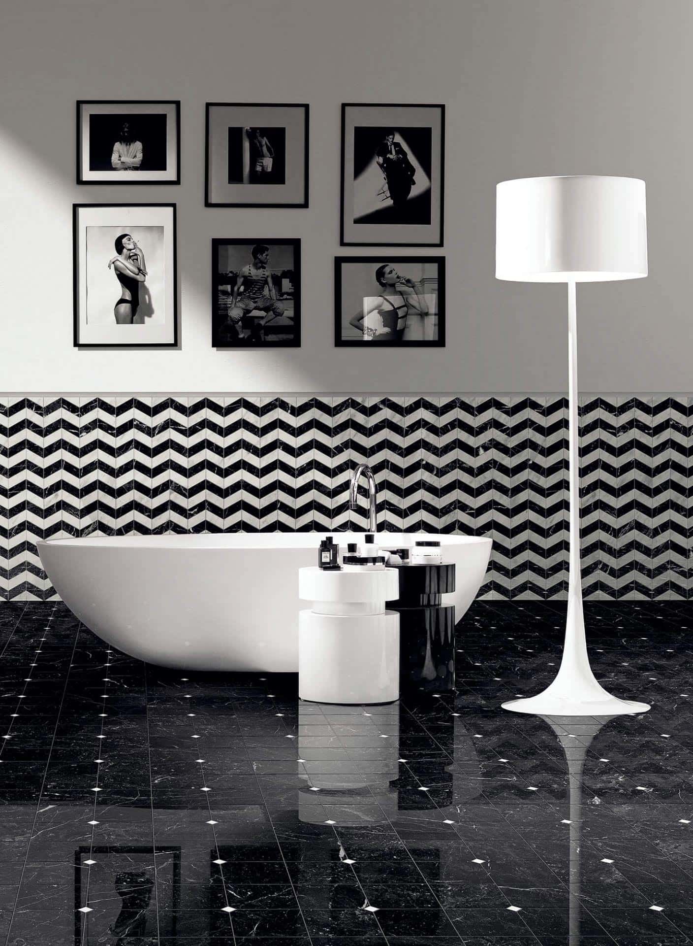 Ambiente de casa de banho com decoração a preto e branco, apresentando banheira, candeeiro e quadros. Chão em mármore preto com pormenores brancos. Bisazza, coleção Marmo Lux