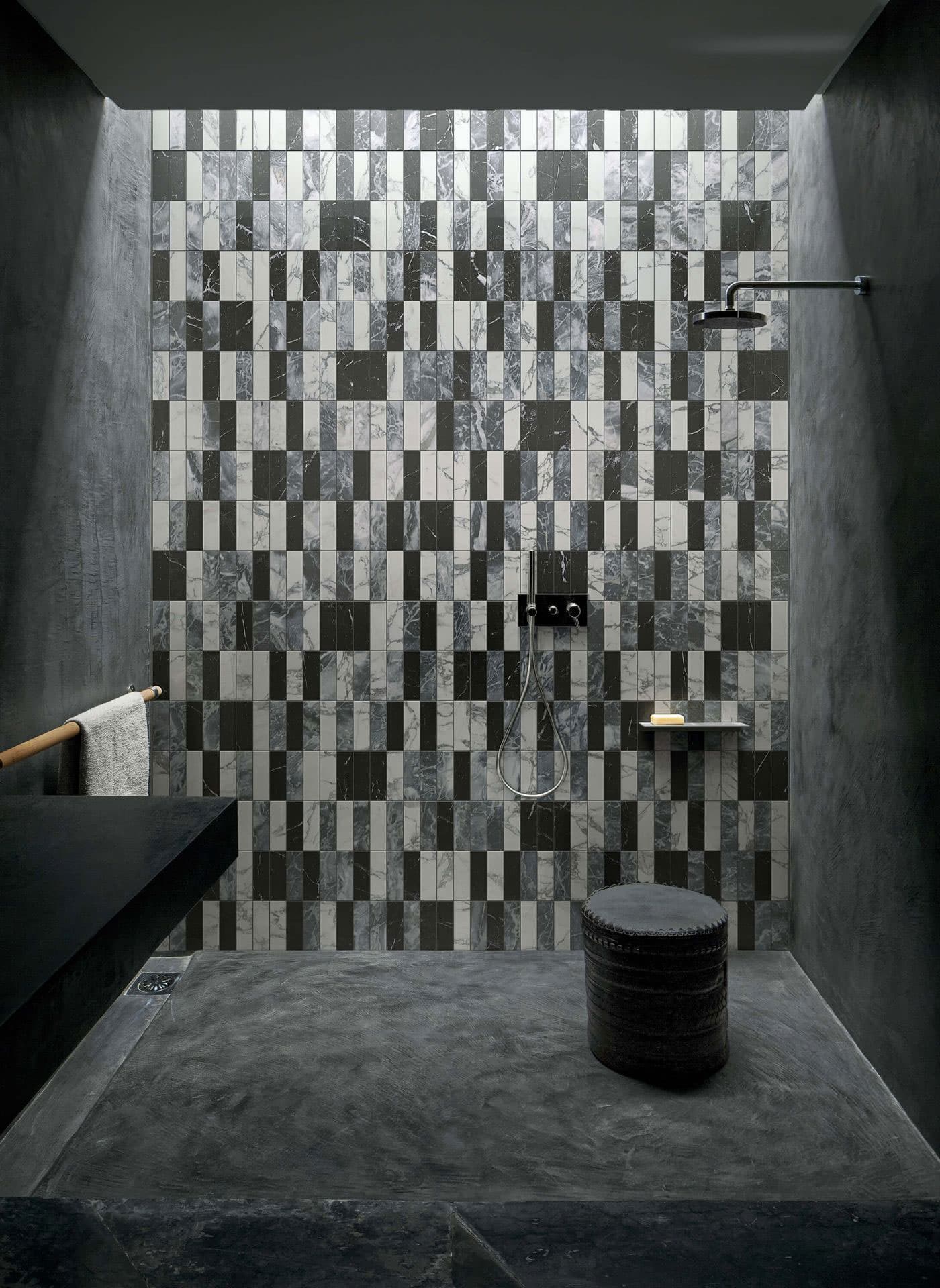 Zona de duche de casa de banho minimalista em tons de preto. Parede em mármore mate com padrão de retângulos em preto, cinza e branco. Acabamento mate e sem reflexo. Bisazza, coleção Marmo em parceria com Studio KO